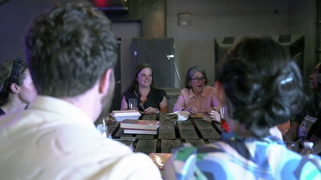 Book Club members relax with cold beverages and discuss their book at No Label Brewing
